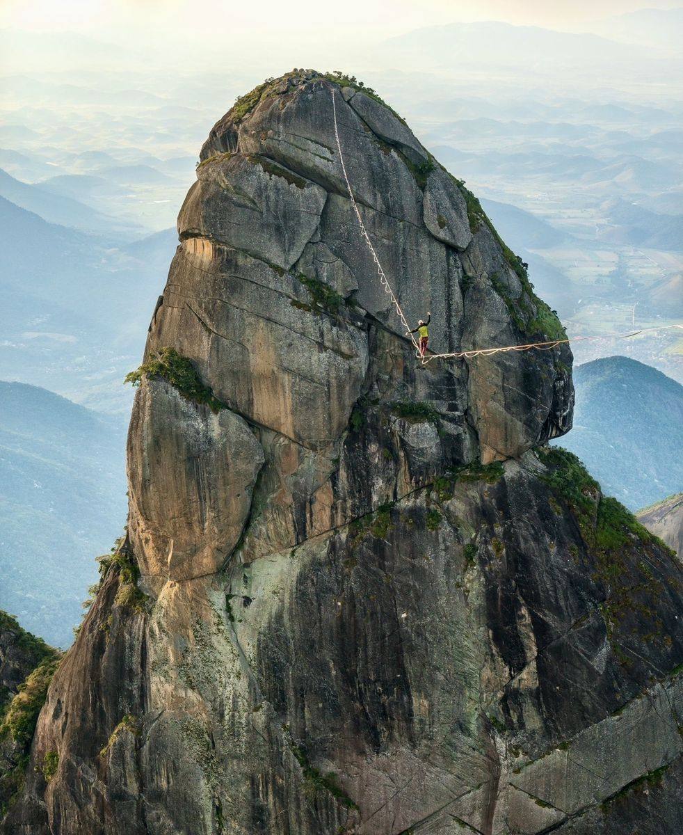 Highlining off a granite pinnacle above the Brazilian mountains