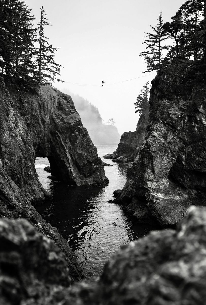 Black-and-white highline between sea stacks on the coast