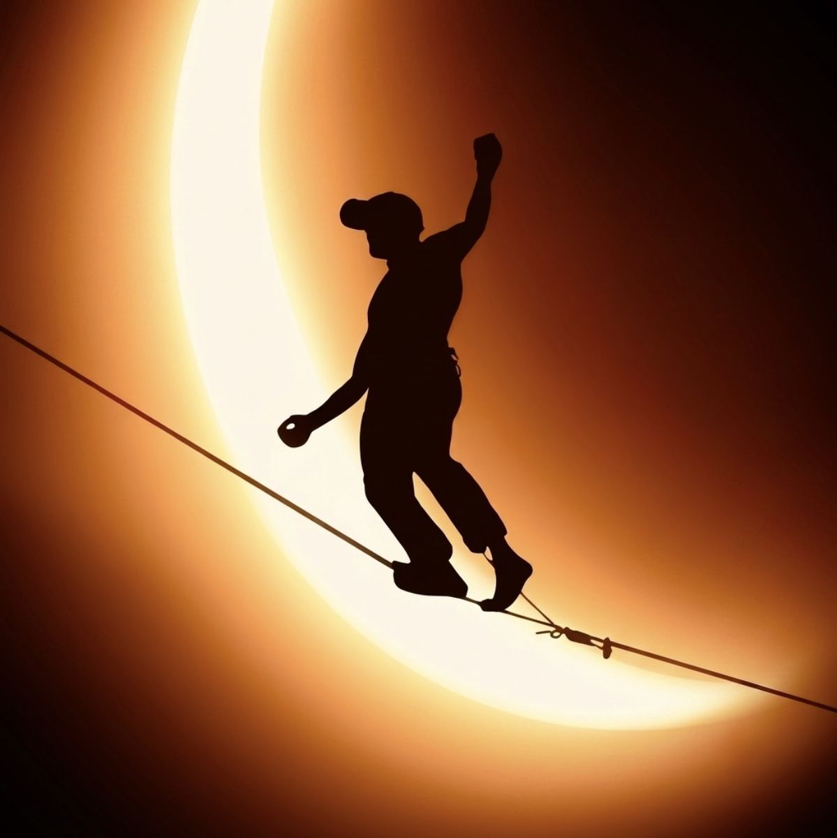 Highliner silhouetted against a solar eclipse